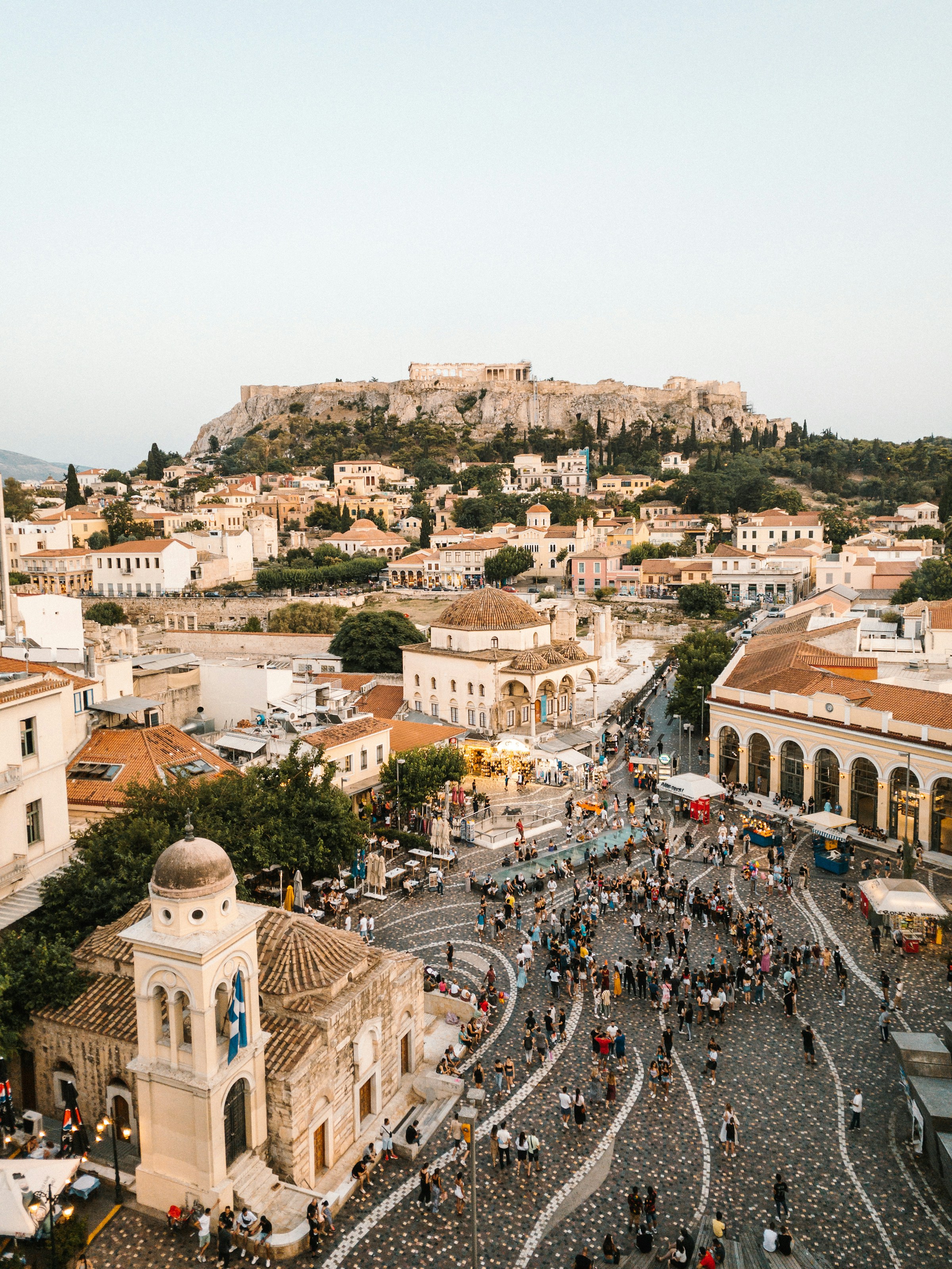 Aerial view of Monastiraki Square bustling with people, set against the backdrop of the Acropolis in Athens, Greece.