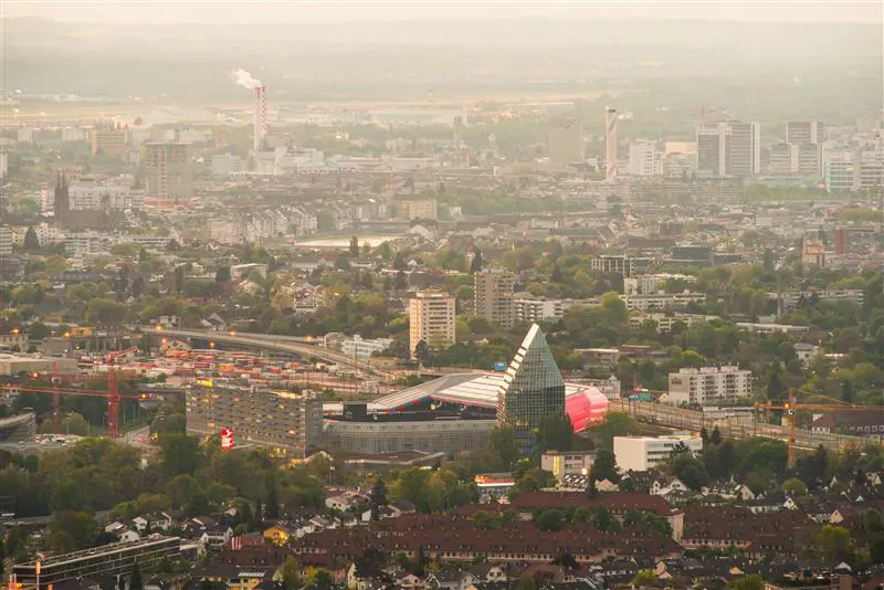 Aerial view of a city with modern buildings and infrastructure, misty light over the skyline.