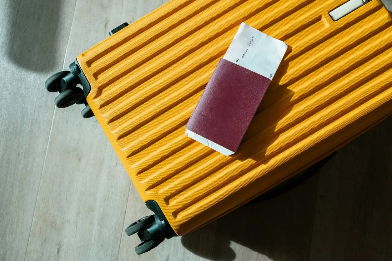 gulresväska med pass och boardingkort ovanpå