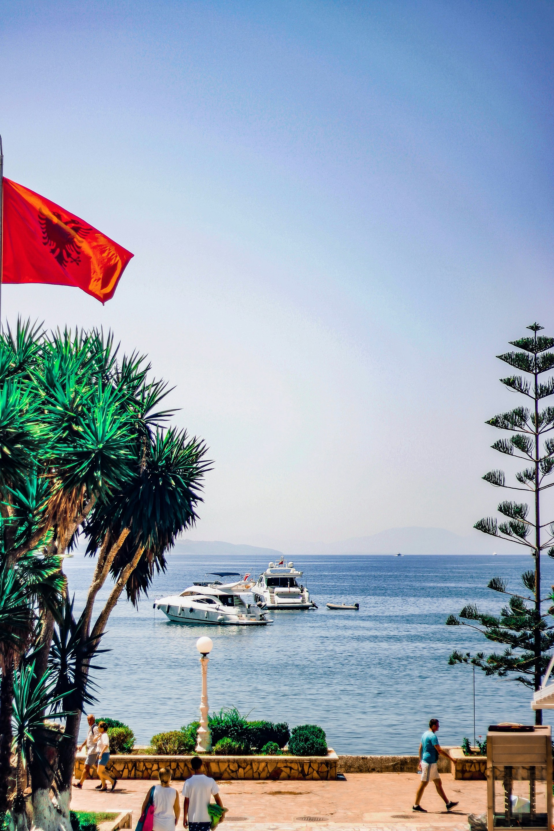 Albanien, kystudsigt med både, palmer og flag