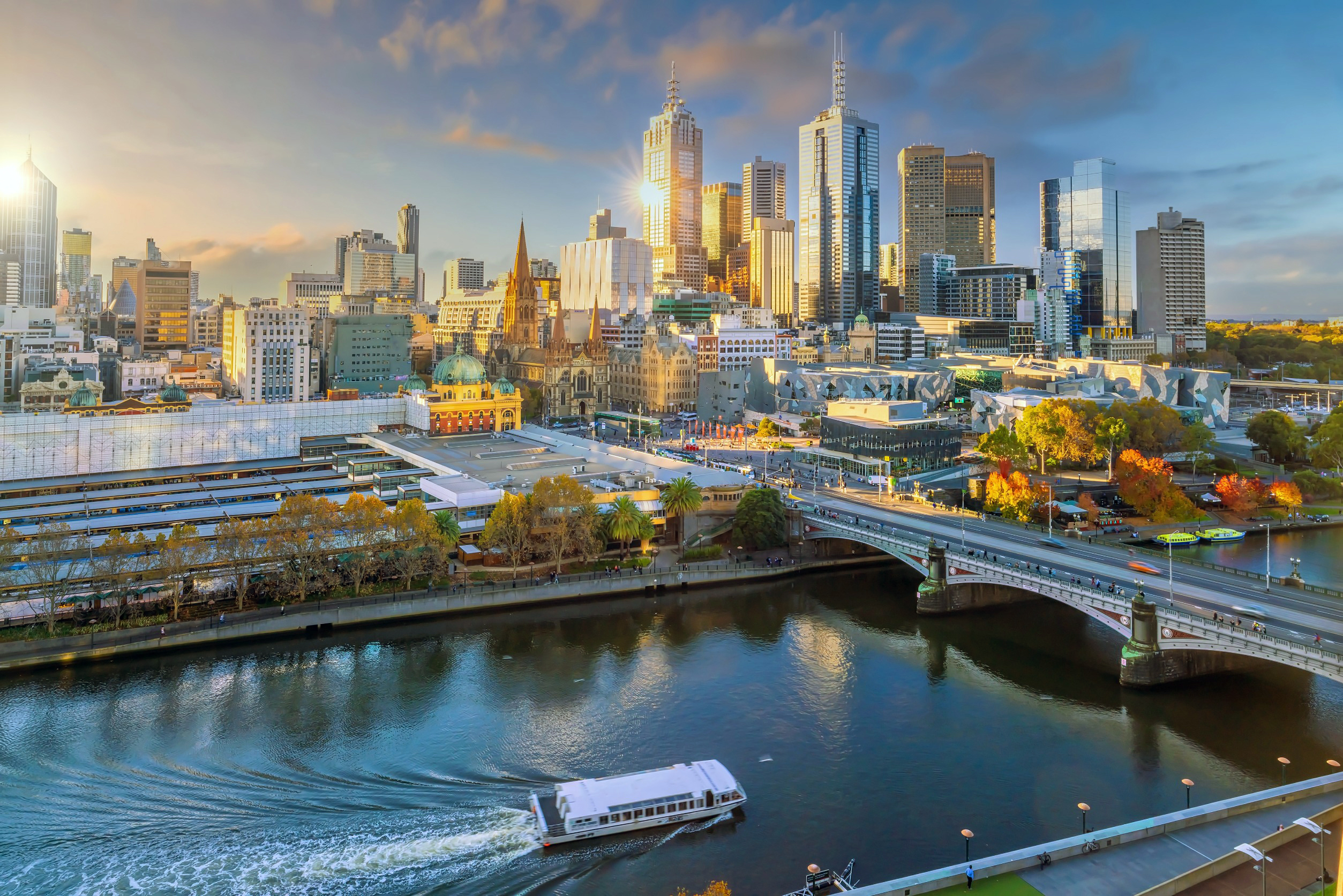 Panoramaudsigt over Melbourne med byens skyline og Yarra-floden i forgrunden ved solnedgang