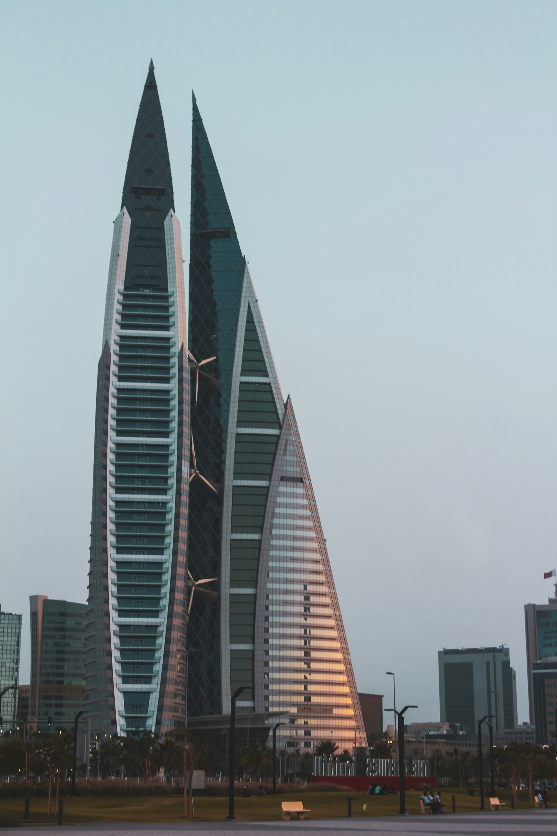 To moderne skyskrabere i Manama, Bahrain, kendt som Bahrain World Trade Center, oplyst af solnedgang