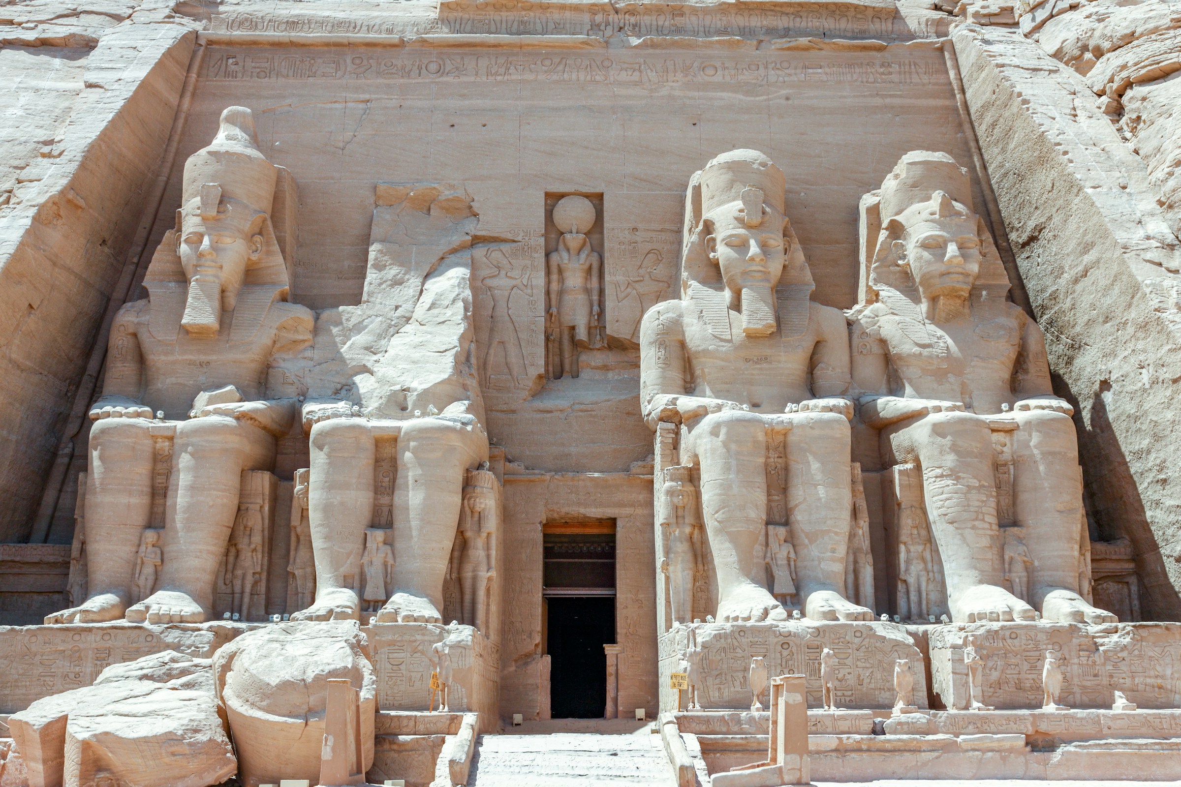 Great Temple of Abu Simbel in Egypt, featuring four colossal statues of Ramses II seated at the entrance, carved into the limestone rock face.