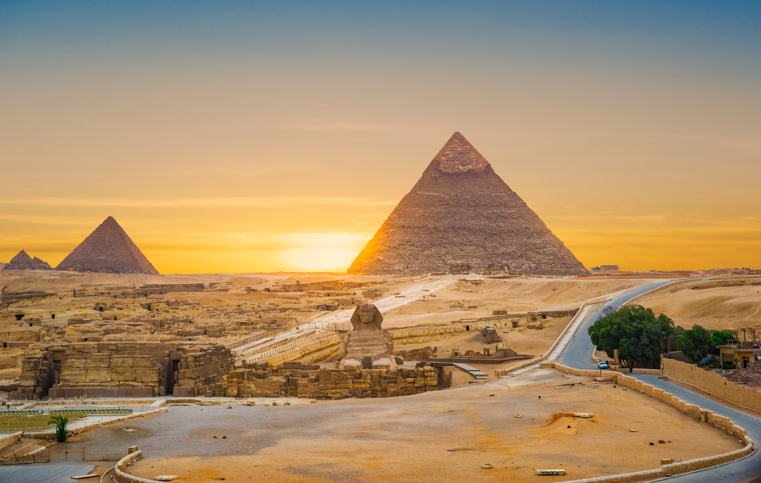 Solnedgang over Giza-pyramiderne i Egypten med Sfinxen i forgrunden