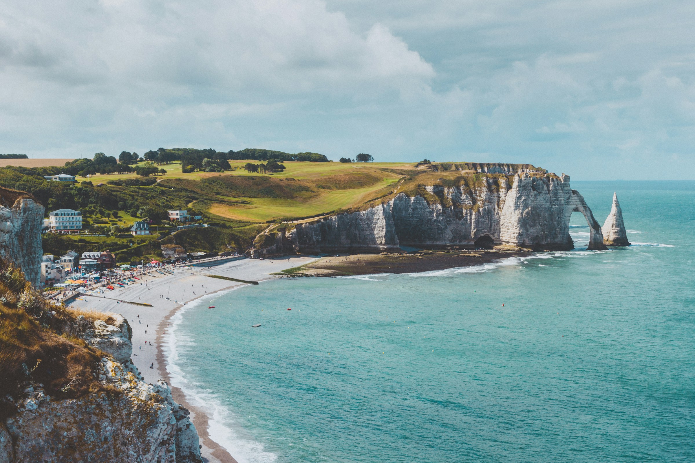 Scenic view of Etretat Cliffs along the Normandy coast, with turquoise waters and beach in France.