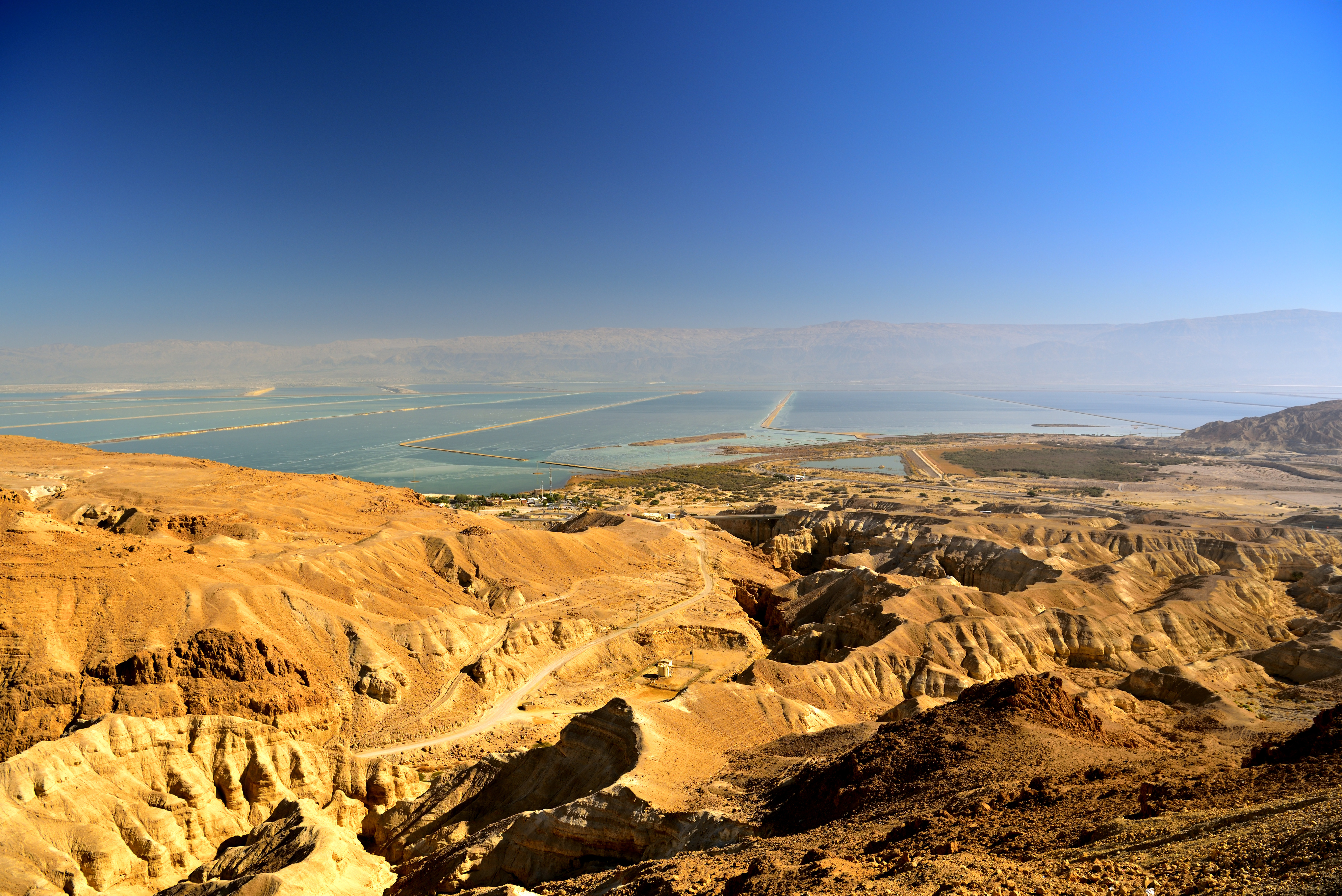 Udsigt over Det Døde Hav fra Masada i Israel på en solrig dag med klare blå himmel og gyldne klippeformationer