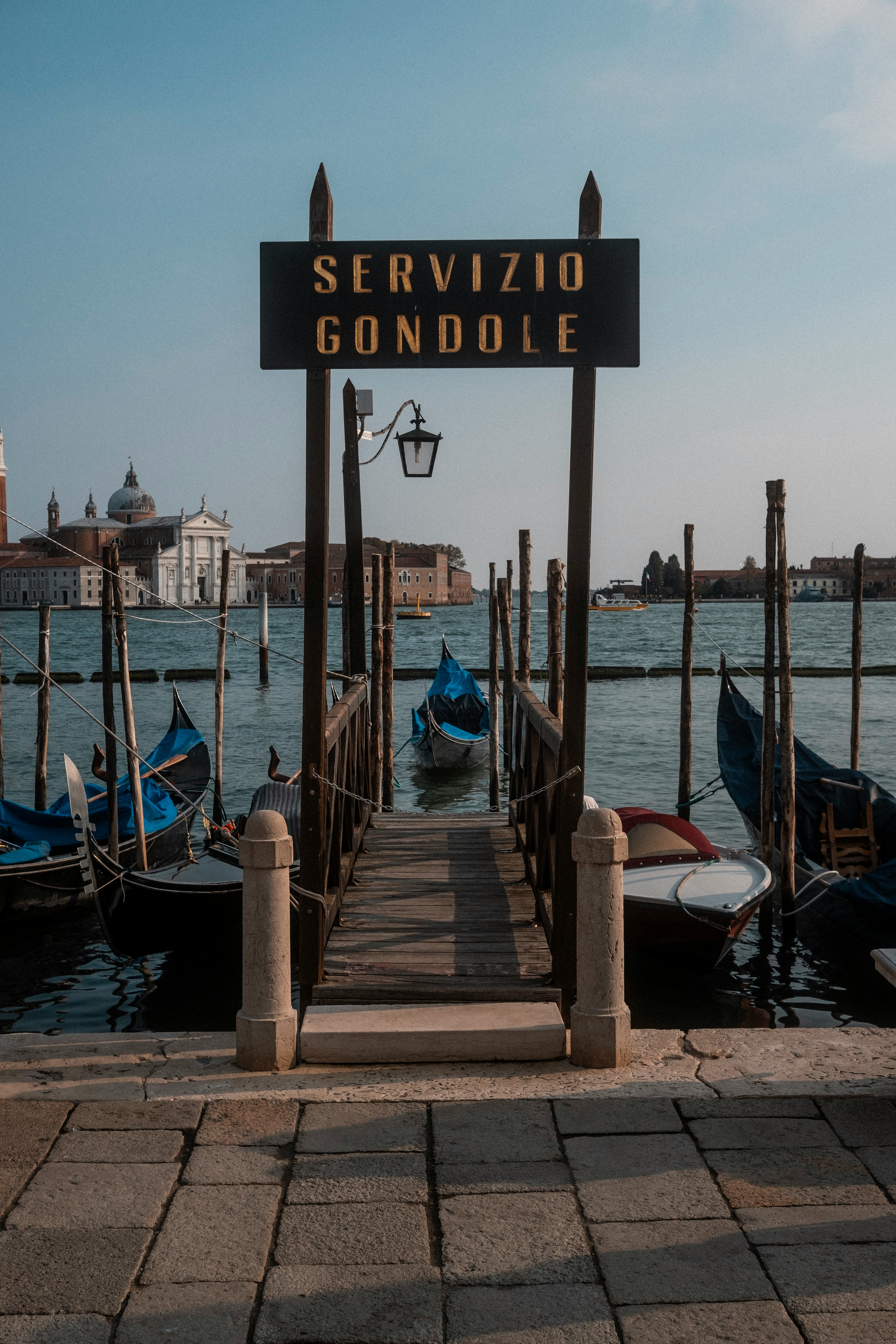 Gondolservice i Venedig, Italien med både langs en anløbsbro og baggrund af byens arkitektur ved vandet