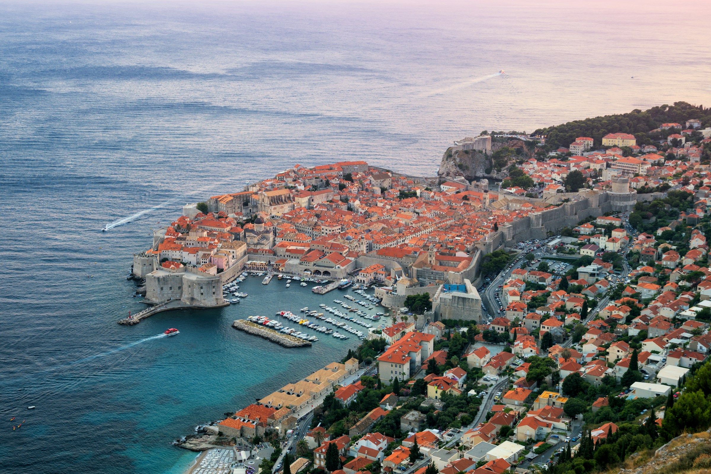 Aerial view of Dubrovnik, Croatia, featuring the historic Old Town with its iconic medieval walls and terracotta rooftops, surrounded by the Adriatic Sea