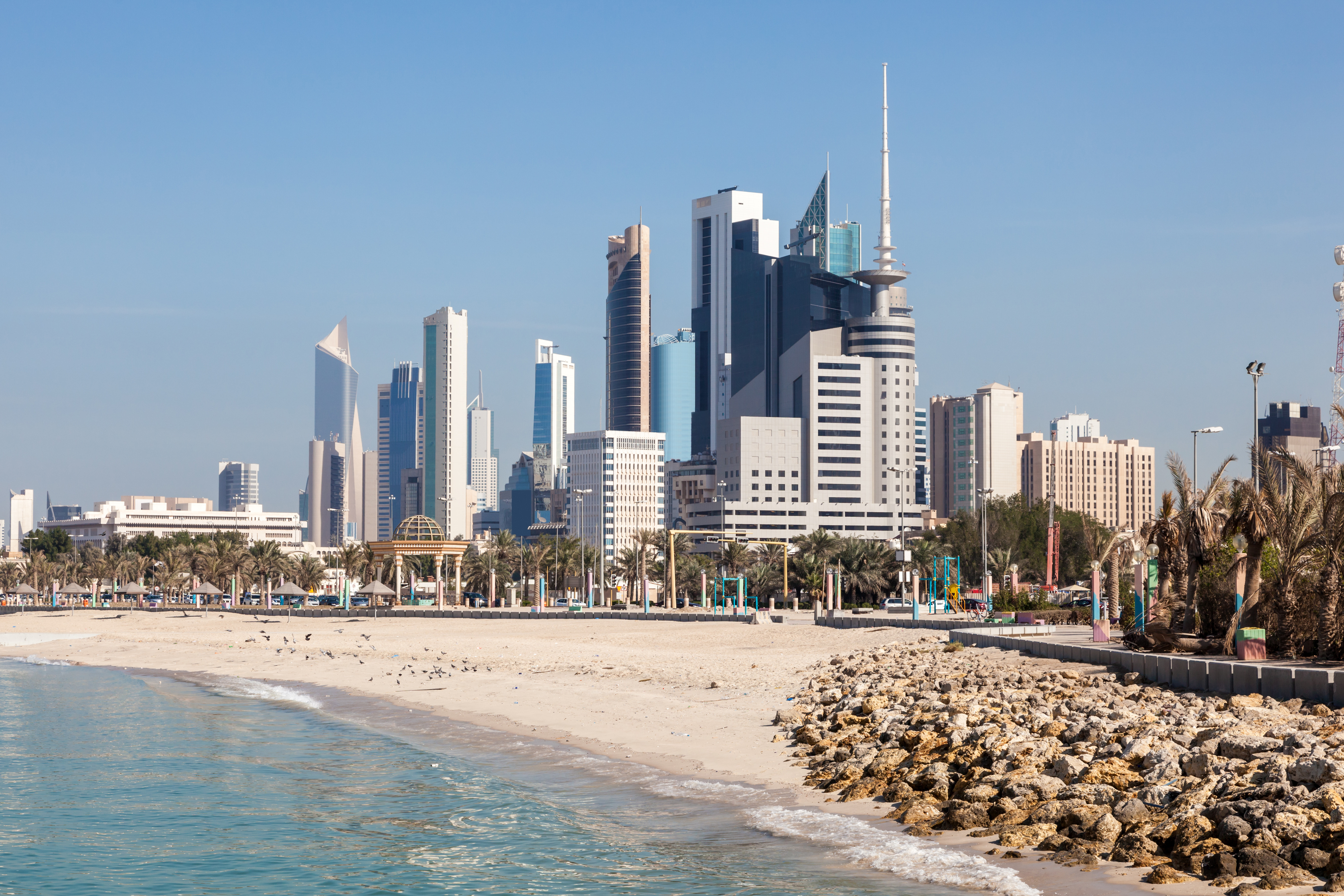Skyline af Kuwait City set fra stranden med moderne skyskrabere og fredeligt kystlandskab