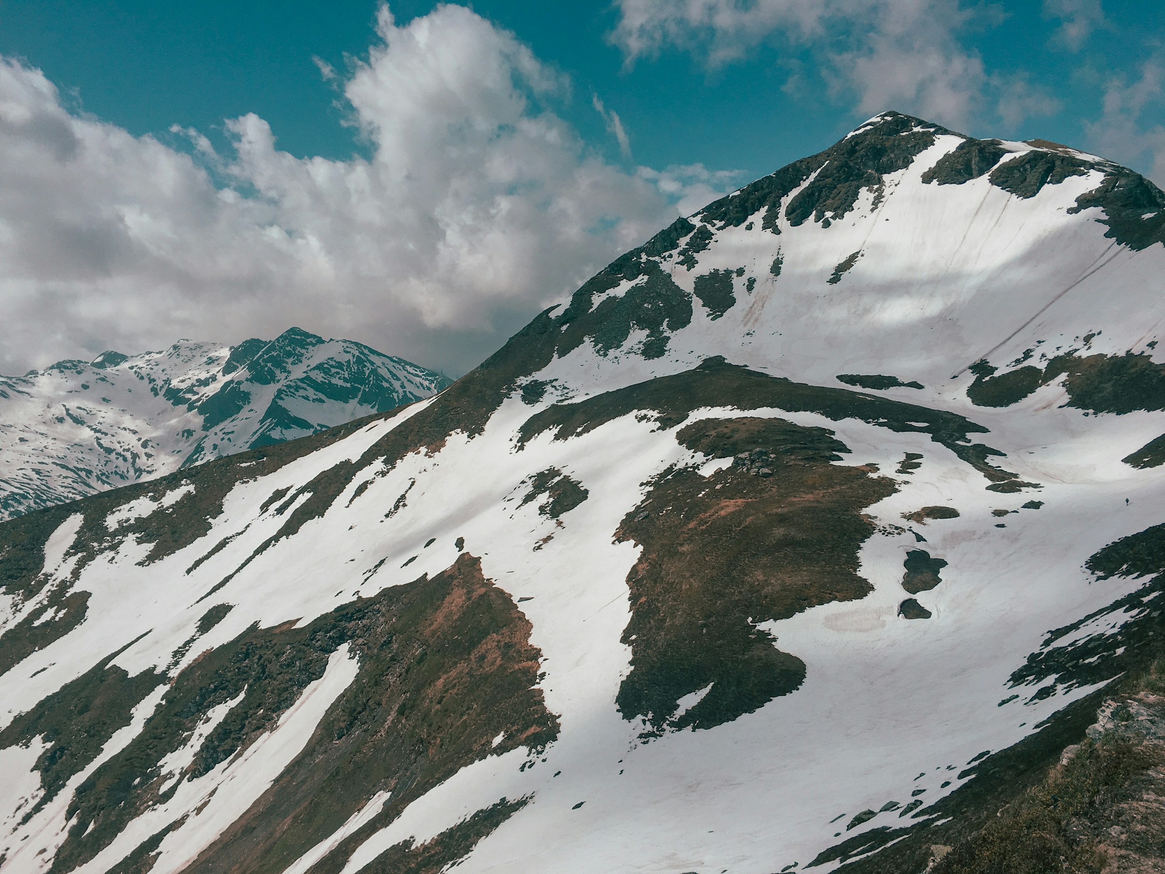 Sneklædte bjergtoppe mod blå himmel i Bad Gastein, Østrigs del af Alperne.