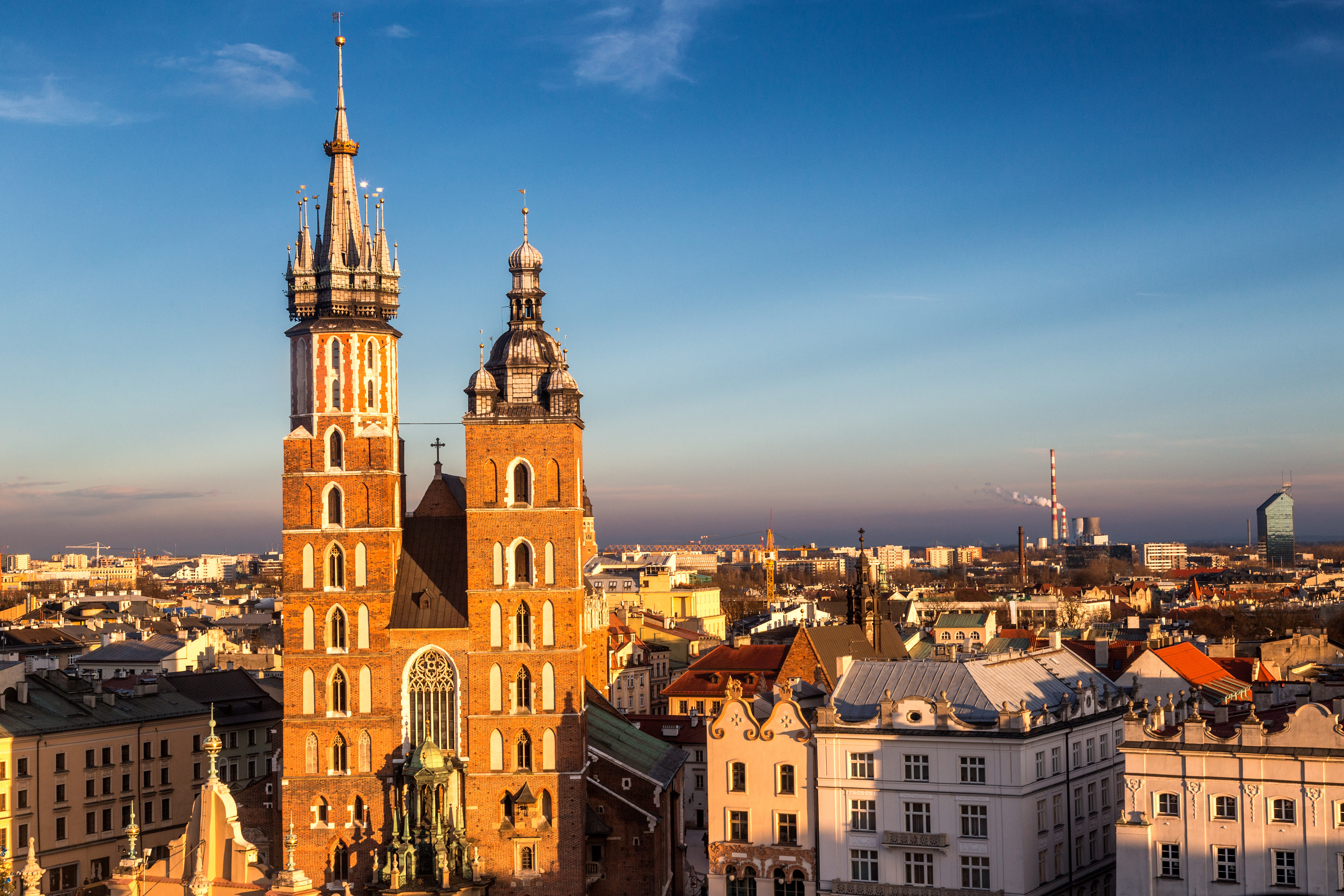 St. Mary's Basilica i Kraków, Polen, med sine ikoniske tårne og gotiske arkitektur under en klar blå himmel