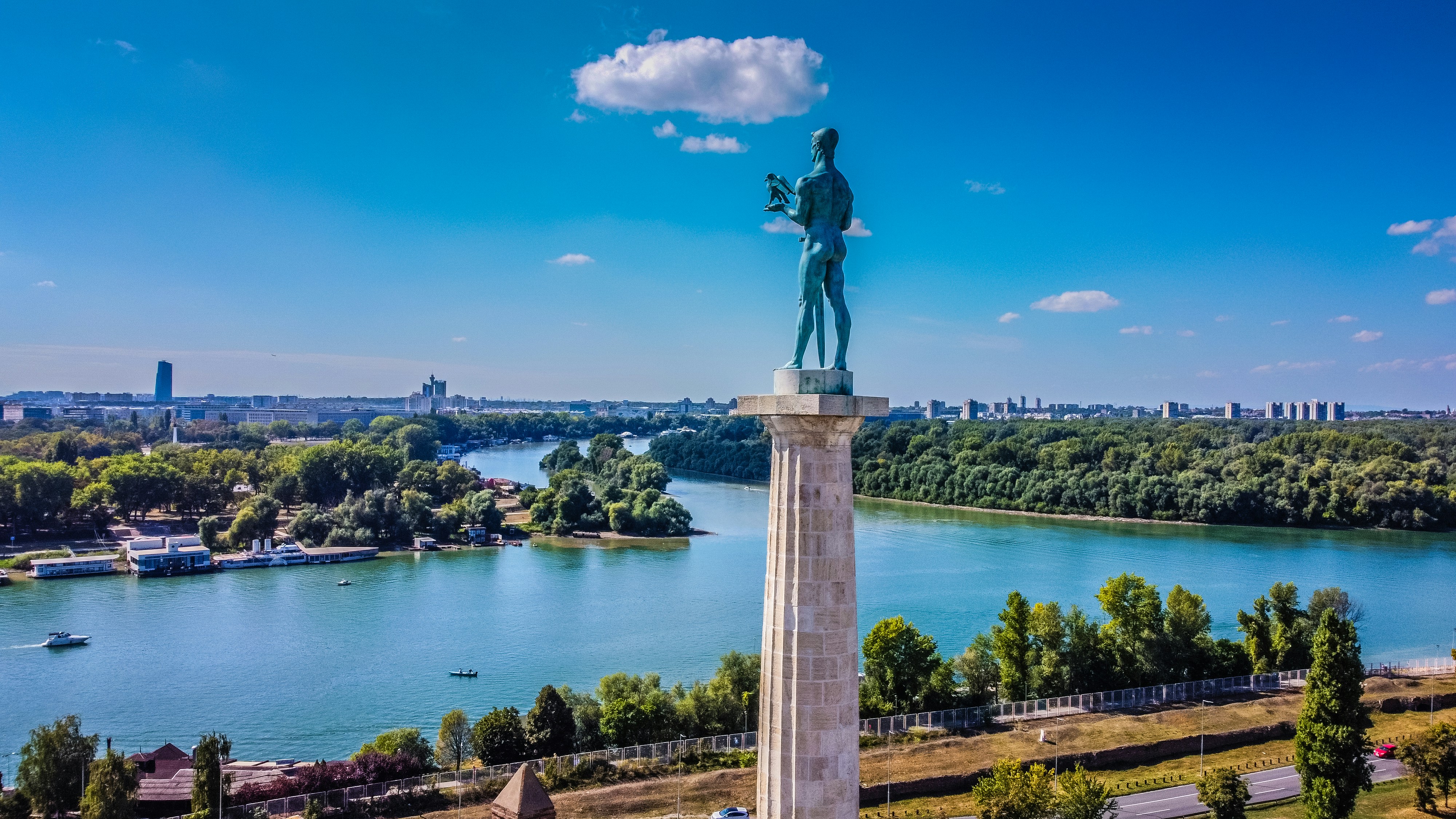 Statue af Pobednik med udsigt over floderne og byens skyline i Beograd, Serbien, under blå himmel