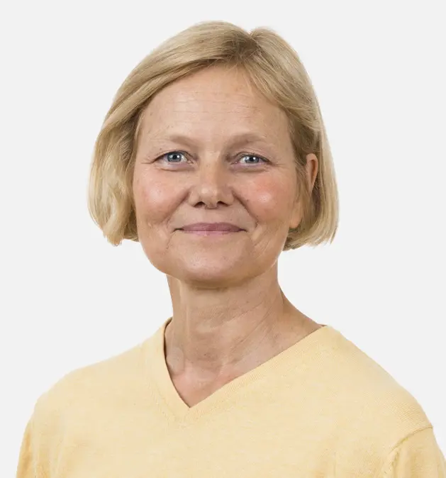 Smilende kvinde med kort blondt hår iført en gul skjorte mod en ensfarvet hvid baggrund